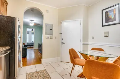 a dining room with a glass table and chairs at Walk to Washington St Hoboken Apt with Balcony! in Hoboken