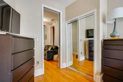 a hallway with a mirror and a living room at Walk to Washington St Hoboken Apt with Balcony! in Hoboken
