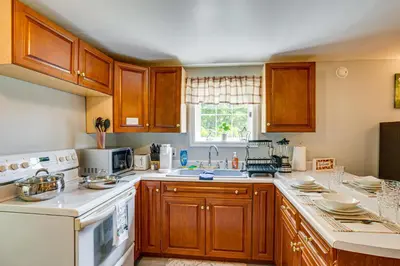 a kitchen with wooden cabinets and white appliances at Honey Bee Farm On-Site Susquehanna Valley Apt! in Dalmatia