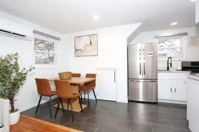 a kitchen with a table and chairs and a refrigerator at NEW Modern NYC Escape near MetLife AmDream MALL EWR in Bergenfield