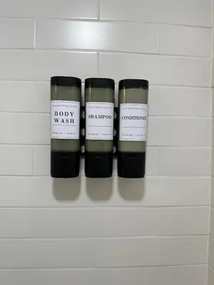 three candles sitting on a shelf in a bathroom at NEW Modern NYC Escape near MetLife AmDream MALL EWR in Bergenfield