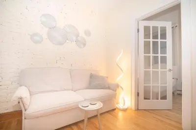 a living room with a white couch and a lamp at East2 Village Center Apartment7 w Full Amenities Great New York Location in New York