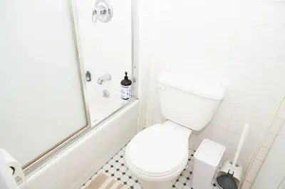 a white bathroom with a toilet and a shower at East2 Village Center Apartment7 w Full Amenities Great New York Location in New York