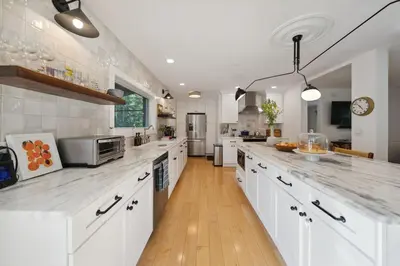 a large kitchen with white counters and white cabinets at Stylish Catskills Escape Near Town & Trails in Livingston Manor