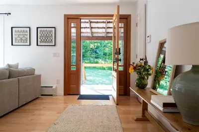 a living room with a couch and a door at Stylish Catskills Escape Near Town & Trails in Livingston Manor