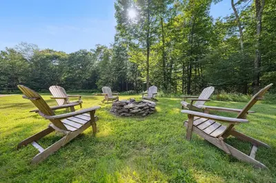 a group of chairs sitting around a fire pit at Stylish Catskills Escape Near Town & Trails in Livingston Manor