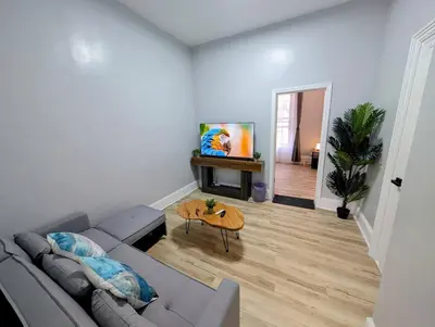 a living room with a couch and a table at Central brownstone in Hoboken Dwntn! 15 mins to NY in Hoboken