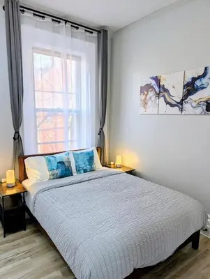a bedroom with a large bed with a window at Central brownstone in Hoboken Dwntn! 15 mins to NY in Hoboken