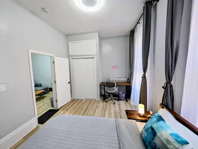 a bedroom with a bed and a desk and a mirror at Central brownstone in Hoboken Dwntn! 15 mins to NY in Hoboken