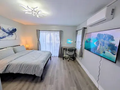 a bedroom with a bed and a large painting on the wall at Newly Renovated Charming Apt! 30 Mins to Manhattan in Jersey City