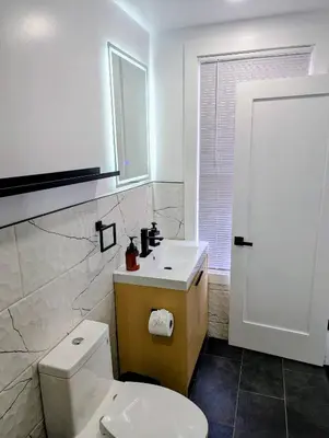 a bathroom with a white toilet and a sink at Newly Renovated Charming Apt! 30 Mins to Manhattan in Jersey City