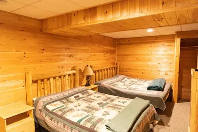 a bedroom with two beds in a log cabin at 6 BR log cabin JFBB ski /HOT TUB in Blakeslee