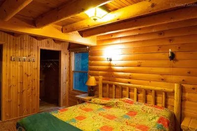 a bedroom with a bed in a wooden cabin at 6 BR log cabin JFBB ski /HOT TUB in Blakeslee