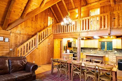 a dining room with a table and chairs in a cabin at 6 BR log cabin JFBB ski /HOT TUB in Blakeslee