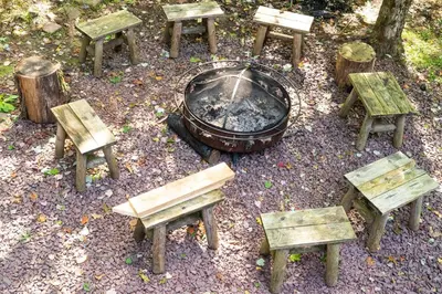 a group of picnic tables and a fire pit at 6 BR log cabin JFBB ski /HOT TUB in Blakeslee