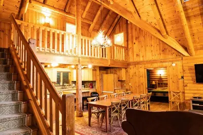 a dining room in a log cabin with a table and chairs at 6 BR log cabin JFBB ski /HOT TUB in Blakeslee