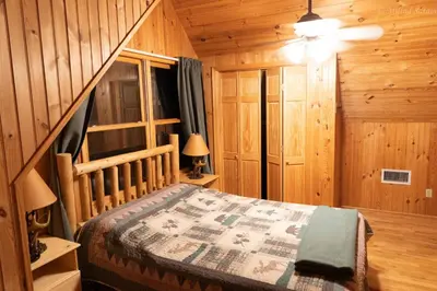 a bedroom with a bed in a wooden cabin at 6 BR log cabin JFBB ski /HOT TUB in Blakeslee