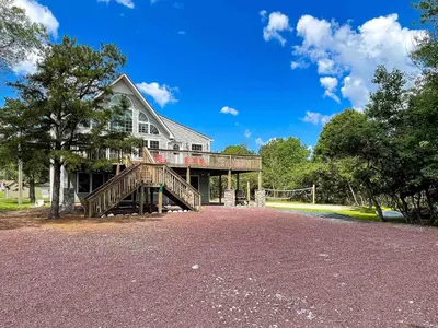 a large house with a large deck and a porch at 9Br lake fr Volley ball/hot tub in Towamensing Trails