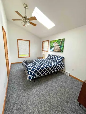 a bedroom with a bed and a ceiling fan at 9Br lake fr Volley ball/hot tub in Towamensing Trails