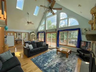 a living room with couches and a ceiling fan at 9Br lake fr Volley ball/hot tub in Towamensing Trails