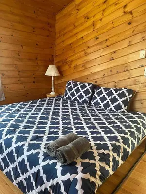 a bedroom with a bed with a wooden wall at 9Br lake fr Volley ball/hot tub in Towamensing Trails