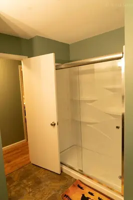 a glass shower stall in a room with green walls at Deer Crest Cabin 5Bedroom near JFBB ski area/Lake in Albrightsville