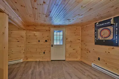 a large room with wooden walls and a white door at NEW ! Lake front Lookout Log Cabin! Private Lake ! in White Haven