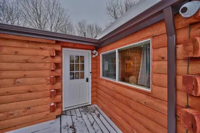 a wooden cabin with a door and a window at NEW ! Lake front Lookout Log Cabin! Private Lake ! in White Haven
