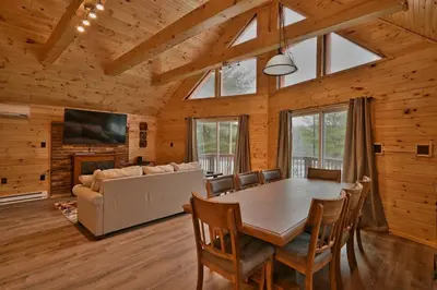a dining room with a table and a couch at NEW ! Lake front Lookout Log Cabin! Private Lake ! in White Haven