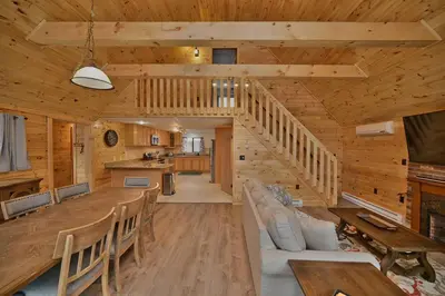 a dining room and kitchen in a log cabin at NEW ! Lake front Lookout Log Cabin! Private Lake ! in White Haven