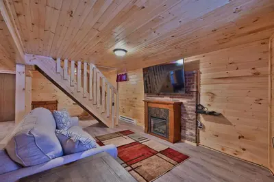 a living room with a couch and a fireplace at NEW ! Lake front Lookout Log Cabin! Private Lake ! in White Haven