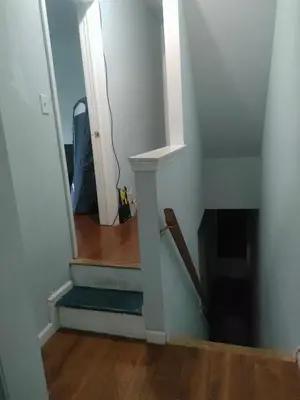 a hallway with a stairway leading to a room with a mirror at 42th Powelton in Philadelphia