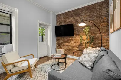 a living room with a couch and a brick wall at Bold Manhattan Base in Prime Nolita in New York