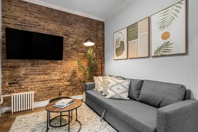 a living room with a couch and a brick wall at Bold Manhattan Base in Prime Nolita in New York