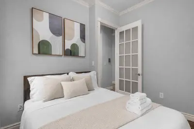 a white bedroom with a large bed with white pillows at Bold Manhattan Base in Prime Nolita in New York