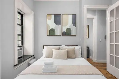 a bedroom with a large white bed and a window at Bold Manhattan Base in Prime Nolita in New York