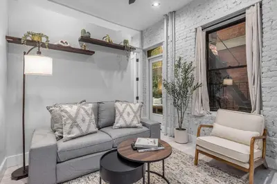 a living room with a couch and a table at Modern Nolita Hideaway in New York