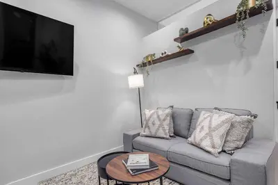 a living room with a gray couch and a table at Modern Nolita Hideaway in New York