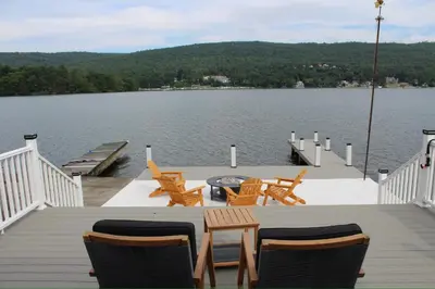 a dock with chairs and tables on the water at Lakefront Haven on Greenwood Lake in West Milford