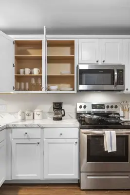 a white kitchen with a stove and a microwave at Traveler Haven XL NYC & NWK with free parking in Newark
