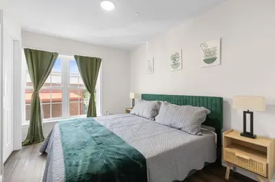 a white bedroom with a bed and a window at Traveler Haven XL NYC & NWK with free parking in Newark