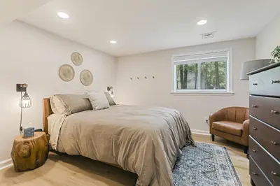 a bedroom with a bed and a dresser and a chair at Pocono Chalet with Sauna/Hot Tub/Firepit/10+ Beds in Long Pond