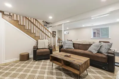 a living room with a couch and a table at Pocono Chalet with Sauna/Hot Tub/Firepit/10+ Beds in Long Pond