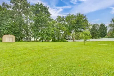 a large grassy yard with a fence and trees at Family Retreat Near Hersheypark with Horse Farm View in Elizabethtown