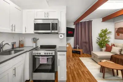 a kitchen and living room with a stove and microwave at Chic Modern Unit in NYC in Brooklyn