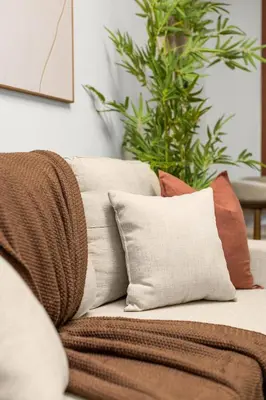 a couch with pillows on it with a plant at Chic Modern Unit in NYC in Brooklyn