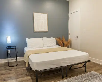 a bedroom with a large bed with a white mattress at 4BR 3Bath Home WDParkingYard Sleeps 10 in Philadelphia