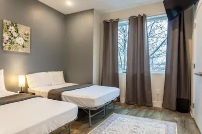 two beds in a room with a window at 4BR 3Bath Home WDParkingYard Sleeps 10 in Philadelphia