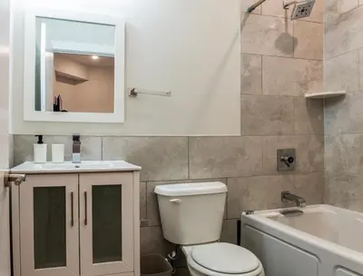 a bathroom with a toilet and a sink and a mirror at 4BR 3Bath Home WDParkingYard Sleeps 10 in Philadelphia