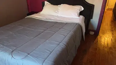 a bed with a blue blanket and white pillows at 2218NColoradoC in Philadelphia
